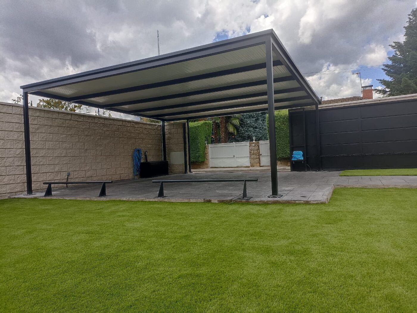 Pérgola plana en jardín, estructura de acero negro