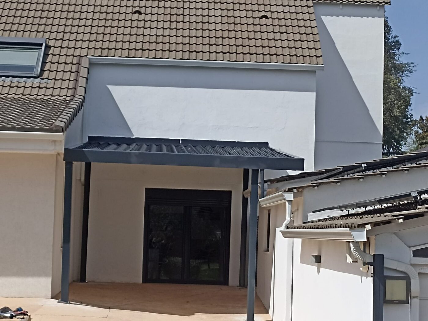 Tejadillo metálico sobre puerta de entrada de vivienda